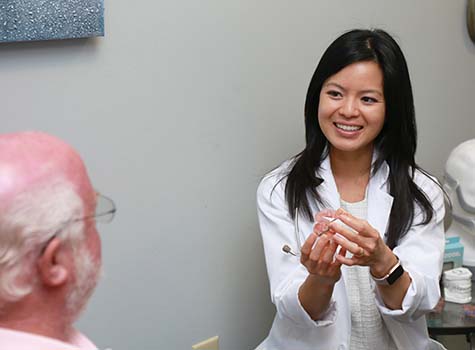 Dr. Marie Nguyen Dibra working with patient