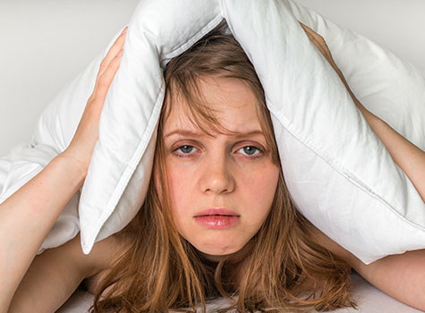 Woman holding pillow over head
