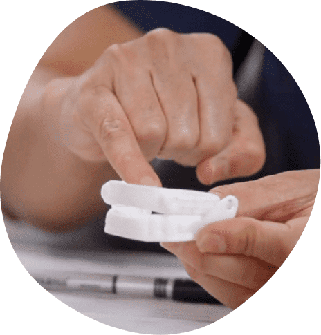 Person holding a white oral appliance
