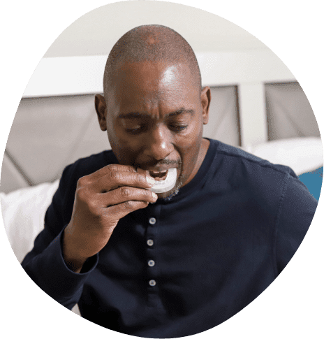 Man placing a white oral appliance in his mouth