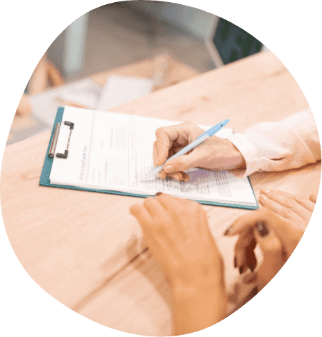 Person filling out paperwork on clipboard
