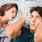 woman snoring and man covering ears
