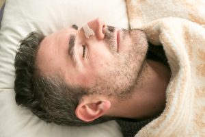 sleeping man with nose strip on