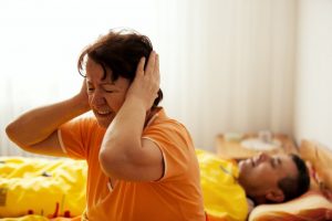 older woman who is frustrated with her partner's snoring