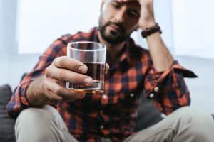 man drinking a glass of alcohol