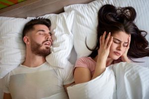 snoring man with frustrated partner