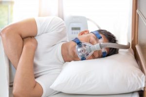 man sleeping with a CPAP mask