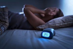 woman suffering from insomnia with the clock